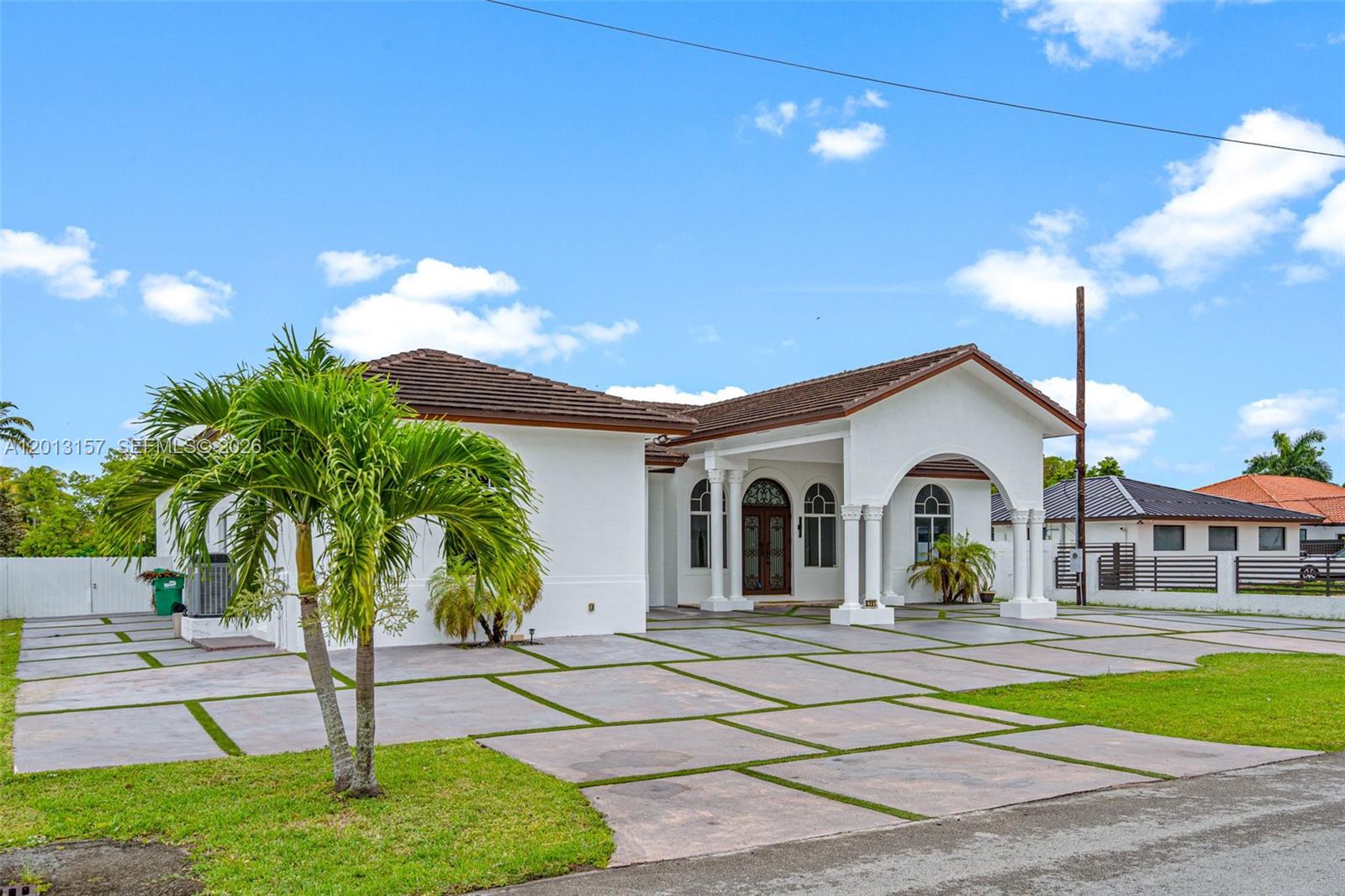 A white single-story house features a large paved driveway and a covered arched entryway — 3201 SW 129th Ave, Miami FL 33175, MIAMI, FL