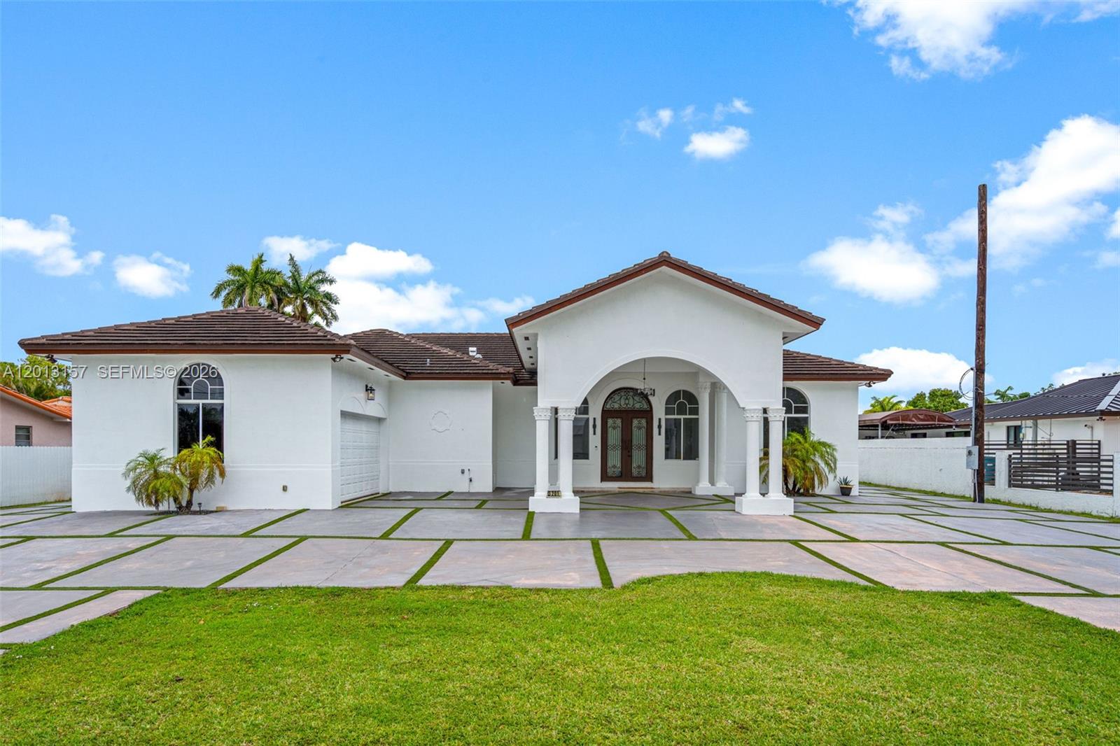 A white single-story house with a tiled roof, arched entryway, and a paved driveway — 3201 SW 129th Ave, Miami FL 33175, MIAMI, FL