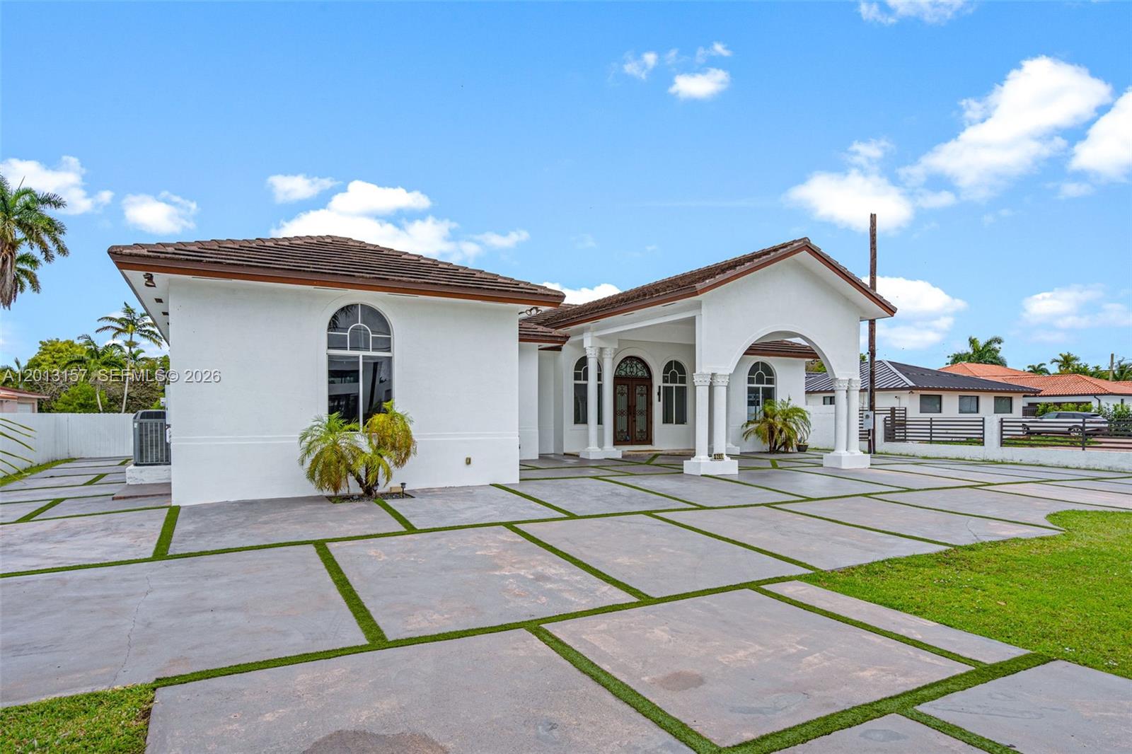 A white single-story house features a large concrete driveway with artificial turf grid lines — 3201 SW 129th Ave, Miami FL 33175, MIAMI, FL
