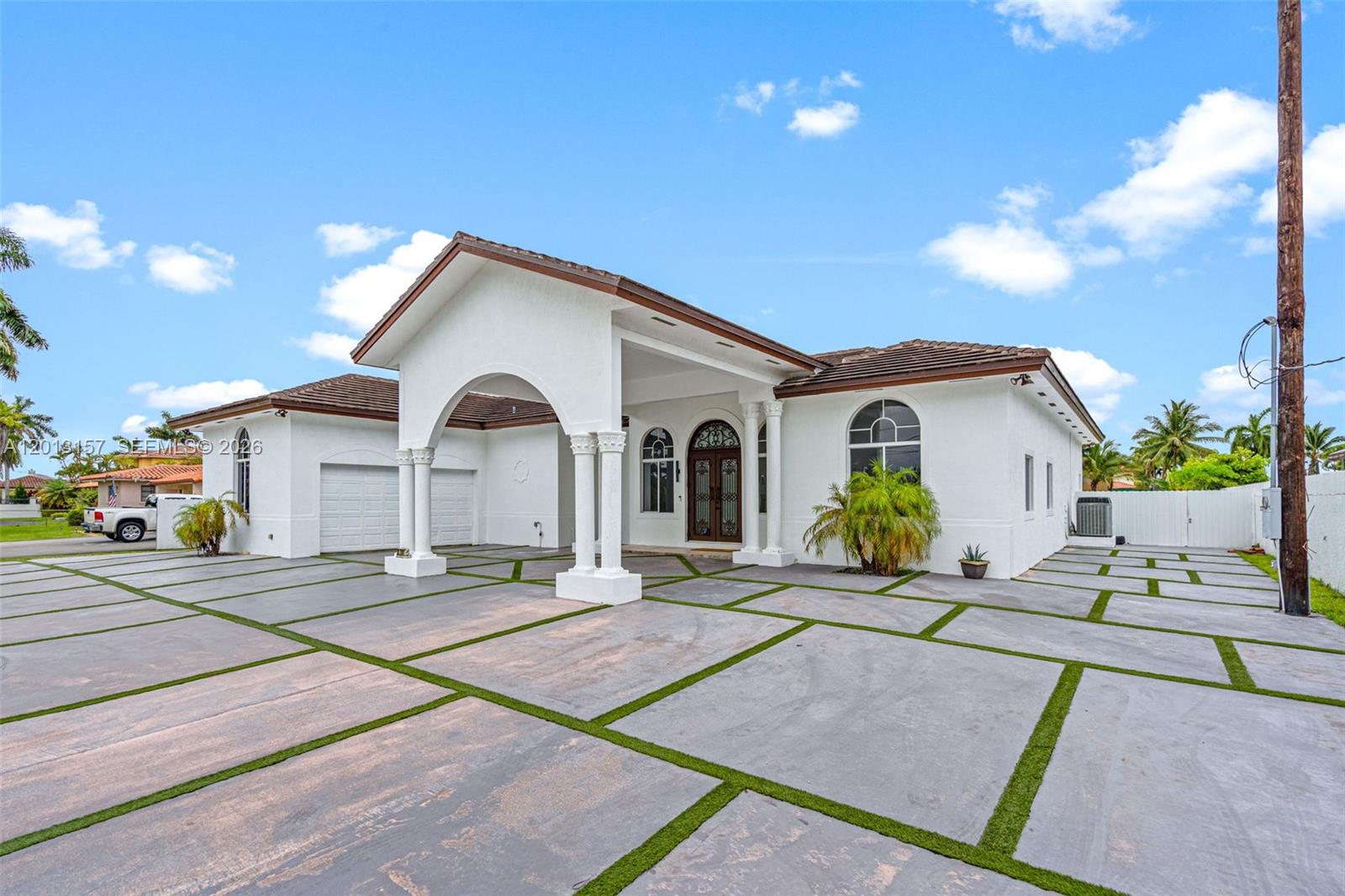 A white single-story house features a large arched portico and a grid-patterned concrete driveway — 3201 SW 129th Ave, Miami FL 33175, MIAMI, FL
