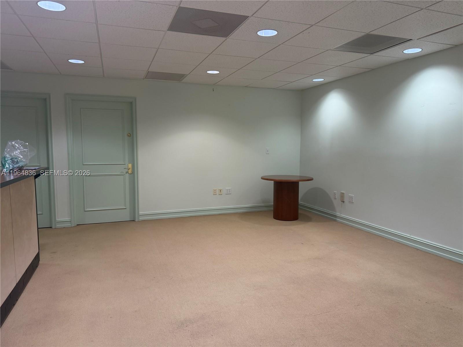 An empty office room features light green walls, beige carpeting, and a drop ceiling — 2435 Hollywood Blvd, Hollywood FL 33020, HOLLYWOOD, FL