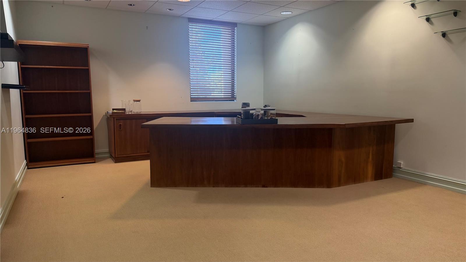 A room features a large wooden desk, a matching bookshelf, and beige carpeting — 2435 Hollywood Blvd, Hollywood FL 33020, HOLLYWOOD, FL