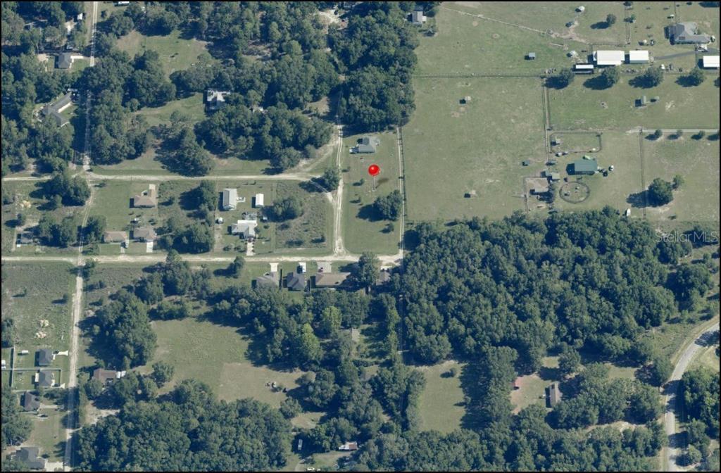 An aerial view shows a house on a large, grassy lot surrounded by trees — Lot 3 SW 130TH COURT, DUNNELLON, FL