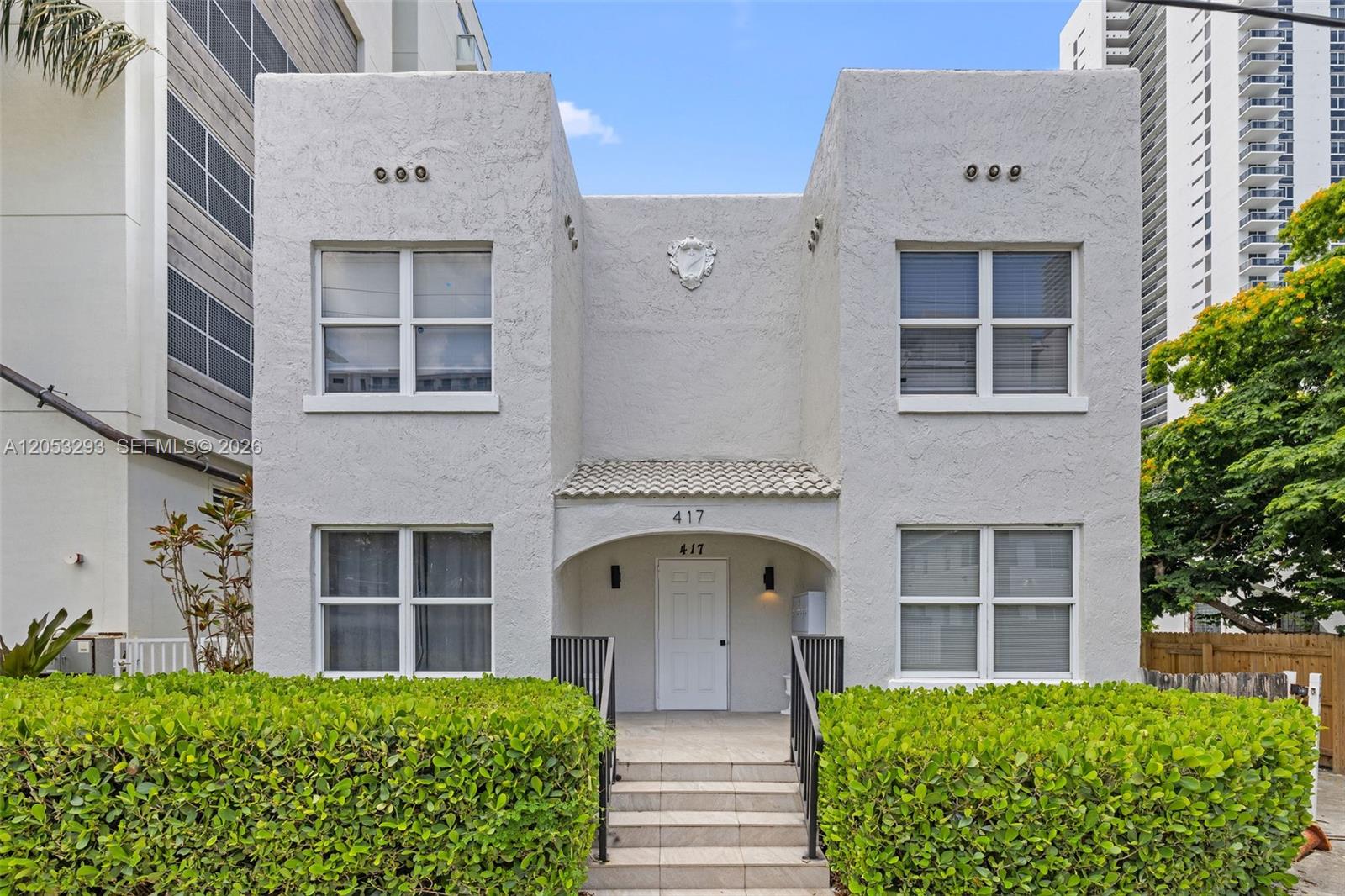 A two-story stucco building with a central entrance, tiled roof, and manicured hedges — 417 NE 26th St # 5, Miami FL 33137, MIAMI, FL