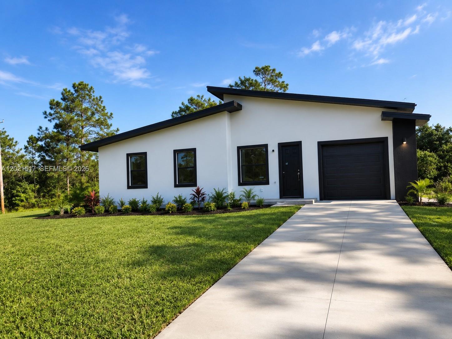 A modern, white single-story house with a black roof, trim, and garage door — 703 LONG ISLAND, Lehigh Acres FL 33974, LEHIGH ACRES, FL