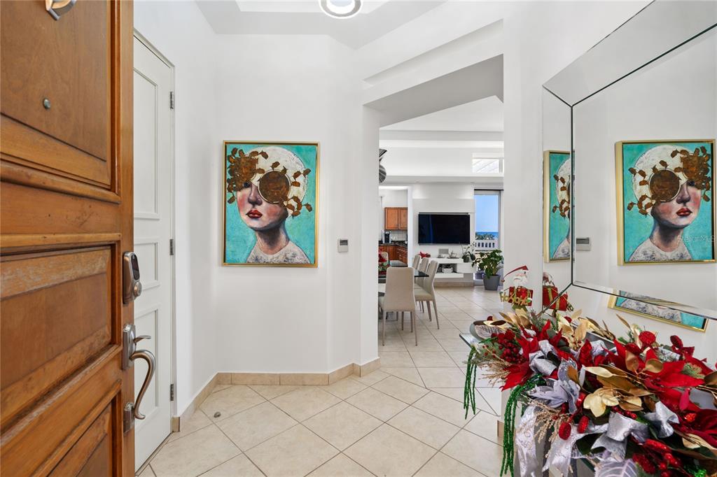 A tiled entryway leads into a dining area and living room with a large mirror — 100 OCEAN DRIVE UNIT 154, HUMACAO, PR