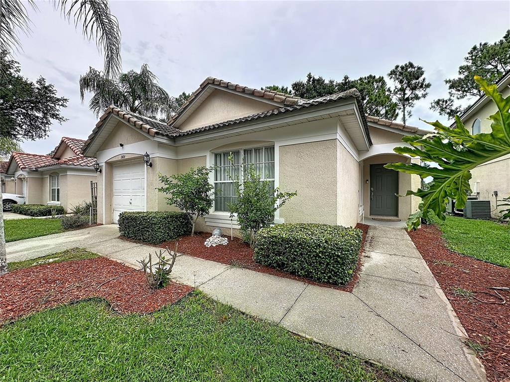 A single-story stucco house with a tiled roof, a one-car garage, and a front walkway — 2464 SAINT AUGUSTINE BOULEVARD, HAINES CITY, FL