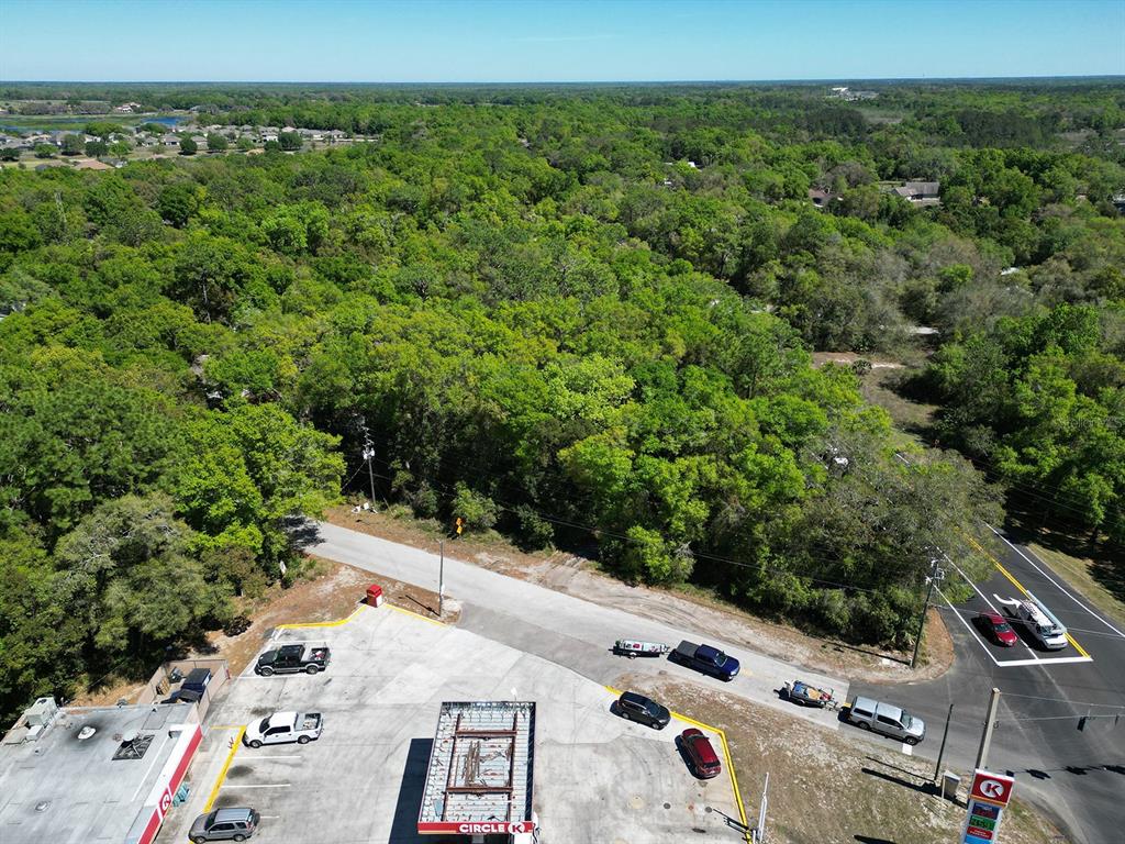 An intersection with traffic lights, road markings, and surrounding trees under a clear blue sky — NILES STREET, MOUNT PLYMOUTH, FL