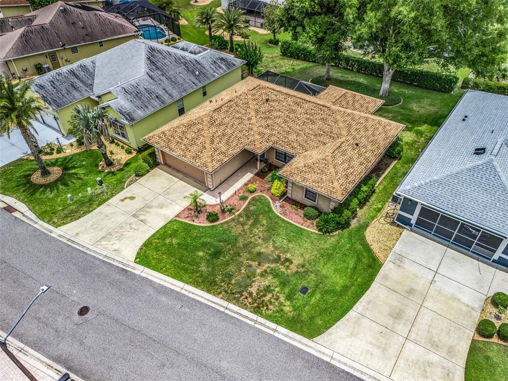 An aerial view shows a tan house with a brown shingled roof and landscaped yard — 17898 SE 125TH CIRCLE, SUMMERFIELD, FL