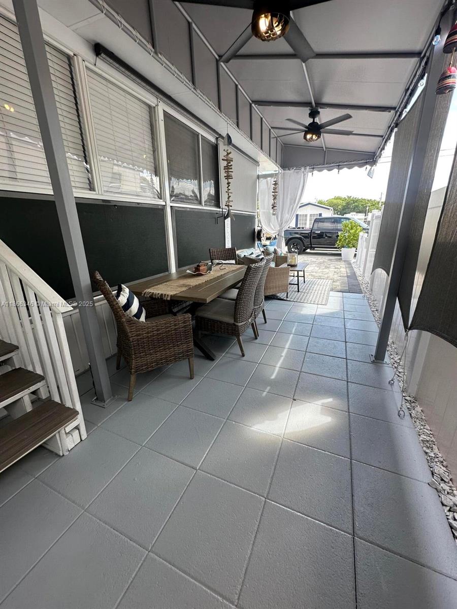 A covered outdoor patio features a dining set, tiled flooring, and ceiling fans — 325 Calusa St #499, Key Largo FL 33037, KEY LARGO, FL
