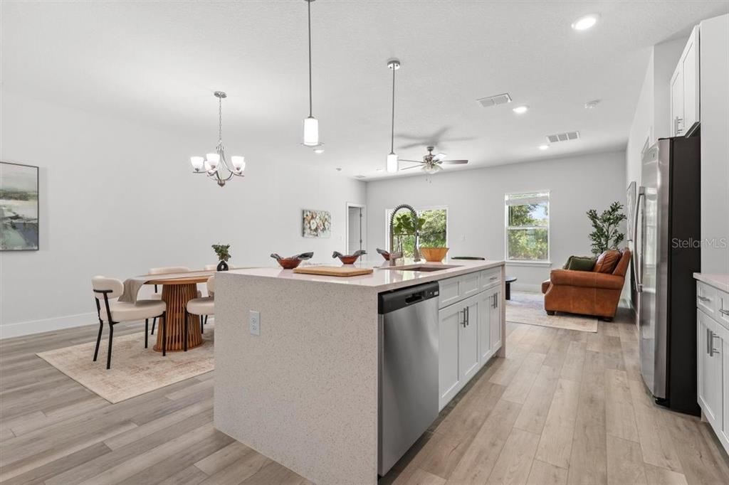 A kitchen with a central island, stainless steel dishwasher, and an adjacent dining area — 3830 GARDENIA DRIVE, INDIAN LAKE ESTATES, FL