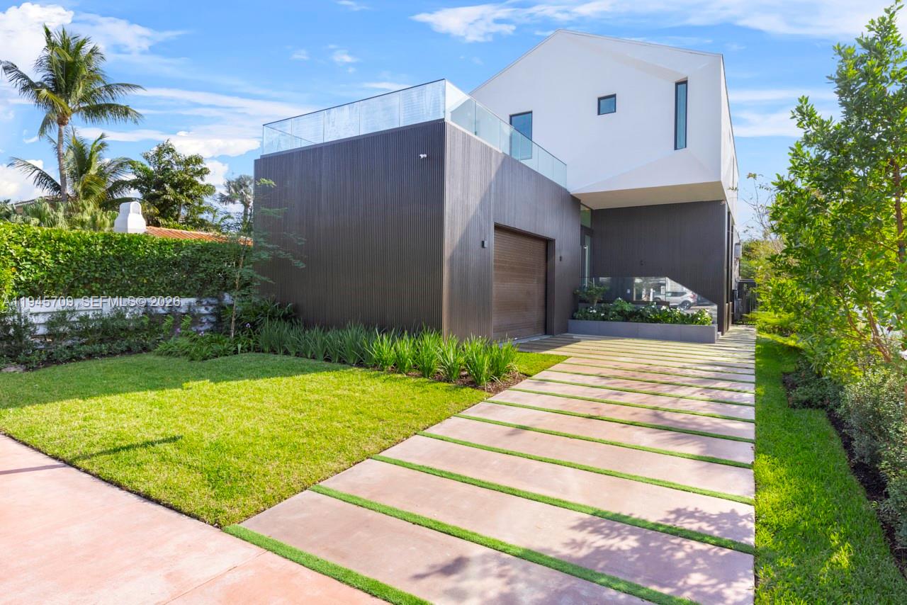 A modern two-story house features a dark wood-paneled garage and a glass-railed rooftop terrace — 536 W 51st St, Miami Beach FL 33140, MIAMI BEACH, FL