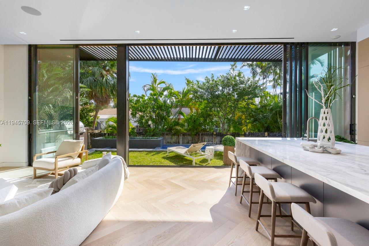 A modern kitchen and living area open to a backyard with a pool and patio — 536 W 51st St, Miami Beach FL 33140, MIAMI BEACH, FL