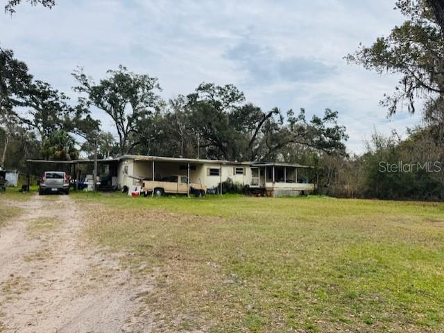 A single-story manufactured home with a carport and a large, grassy yard — 11417 SW 42ND TERRACE, WEBSTER, FL