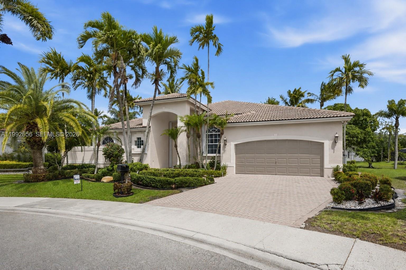 A single-story house with a beige stucco exterior, a tiled roof, and a paved driveway — 3038 Lakewood Dr, Weston FL 33332, WESTON, FL