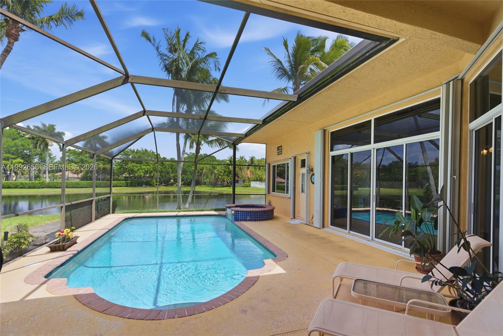 A screened-in patio features a swimming pool, a small hot tub, and lounge chairs — 3038 Lakewood Dr, Weston FL 33332, WESTON, FL