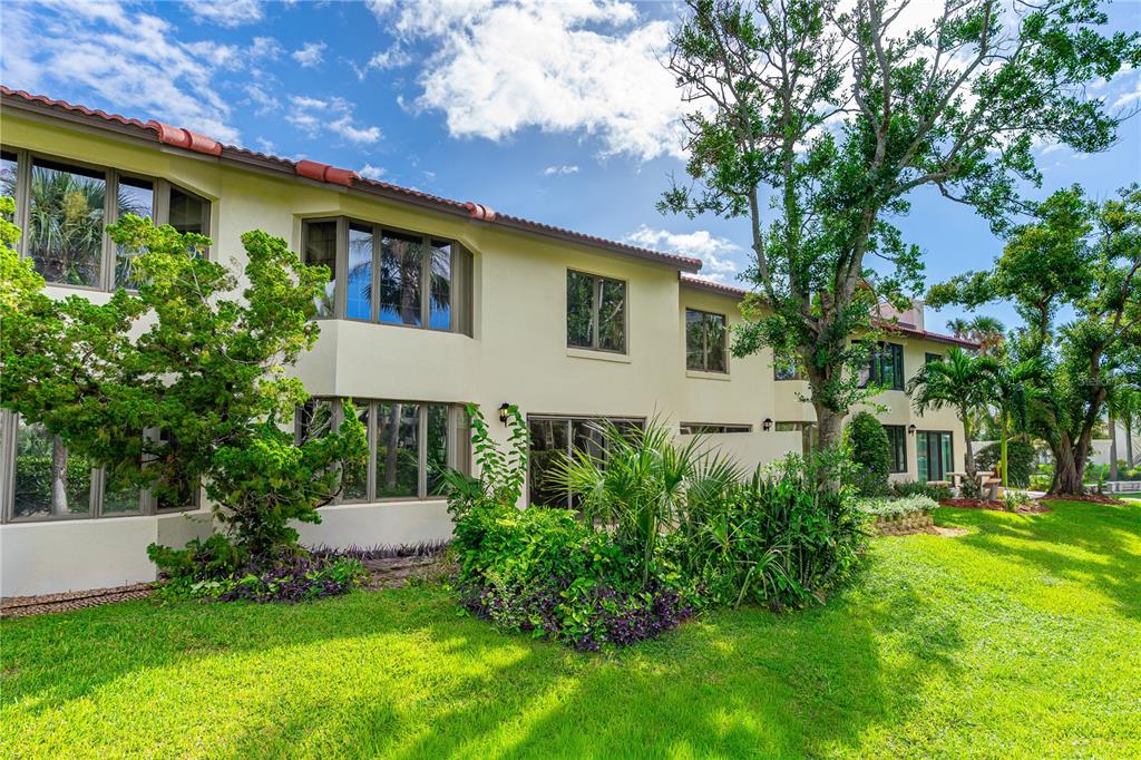 The exterior of a two-story stucco building features a red tile roof and large windows — 2966 OCEANS TRACE, DAYTONA BEACH SHORES, FL