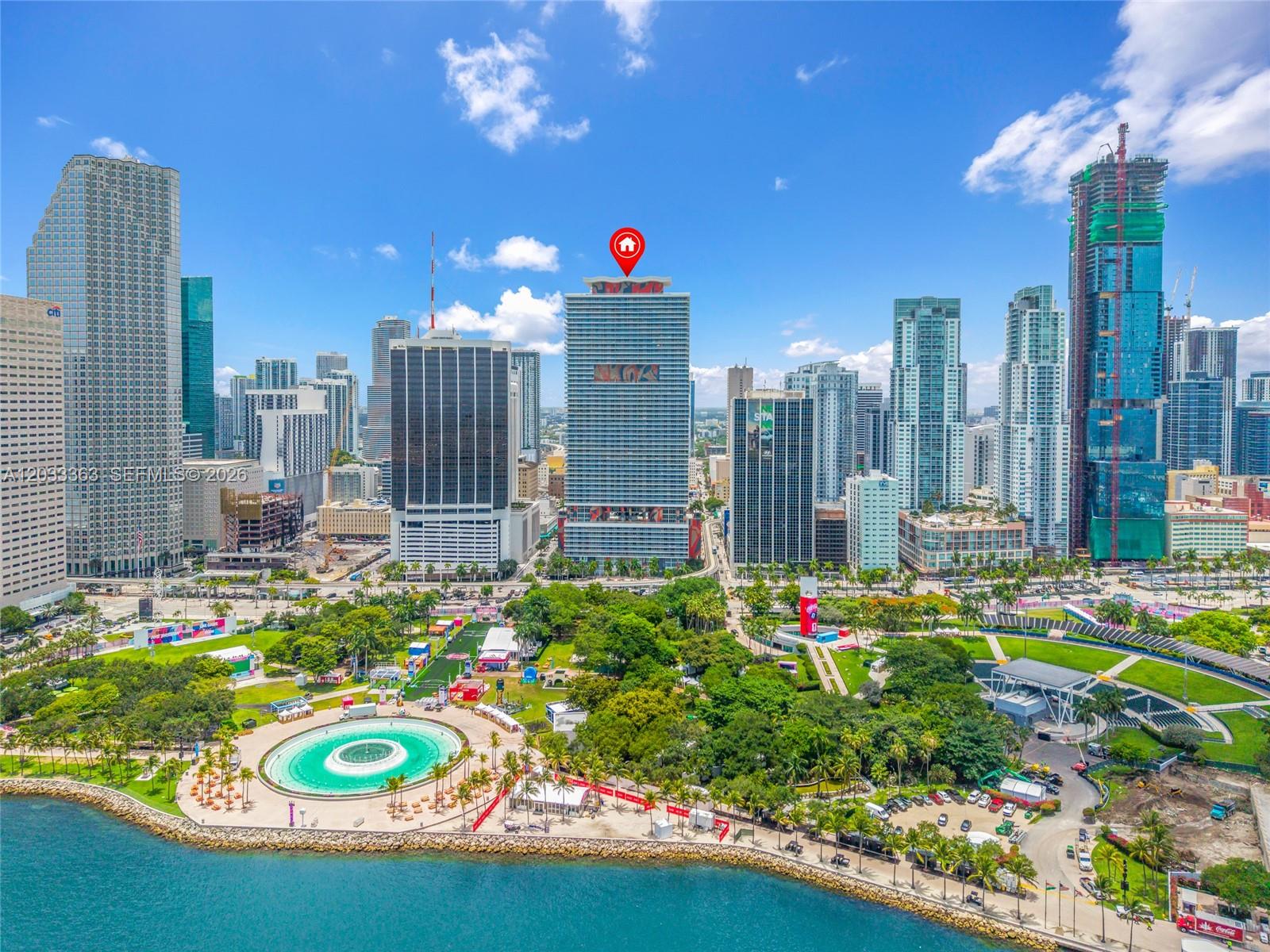 An aerial view of the Miami skyline featuring a prominent building marked with a red icon — 50 Biscayne Blvd # 4307, Miami FL 33132, MIAMI, FL