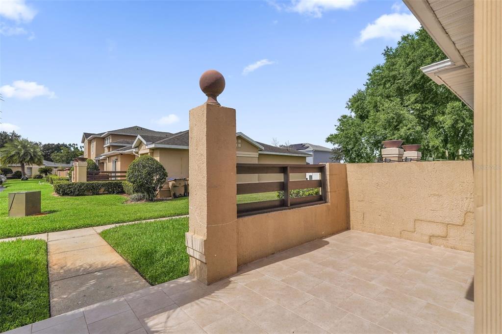 A tiled patio features a stucco privacy wall with a decorative wooden slat insert — 3154 SANDY SHORE LANE, KISSIMMEE, FL