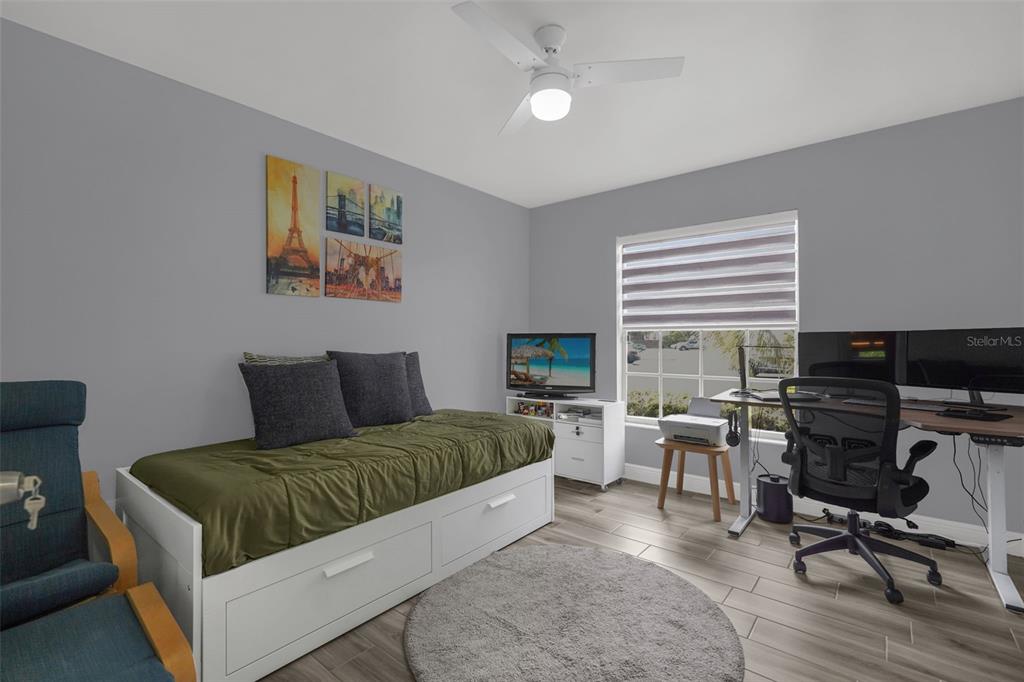 A bedroom features a daybed, a desk with a computer, and a ceiling fan — 3154 SANDY SHORE LANE, KISSIMMEE, FL