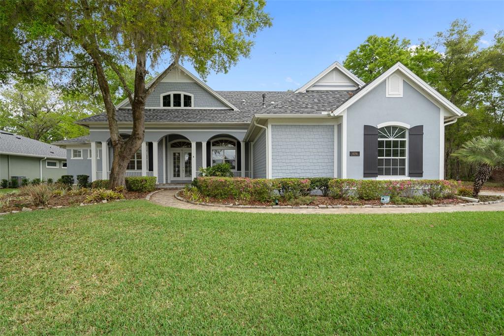 A light blue single-story house with a gray shingled roof and a front lawn — 6096 DUSK ROSE LANE, BROOKSVILLE, FL