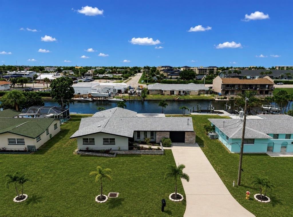 An aerial view of a single-story house with a gray roof and a canal backyard — 1729 BIKINI COURT, CAPE CORAL, FL