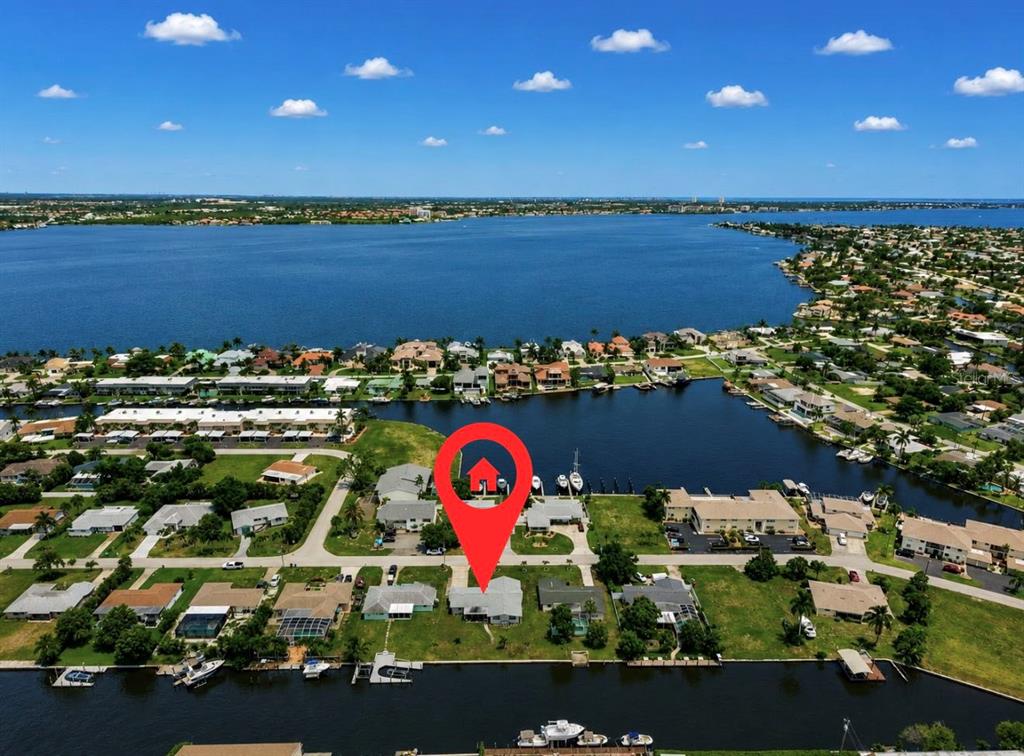 An aerial view of a waterfront residential neighborhood with a red location pin — 1729 BIKINI COURT, CAPE CORAL, FL