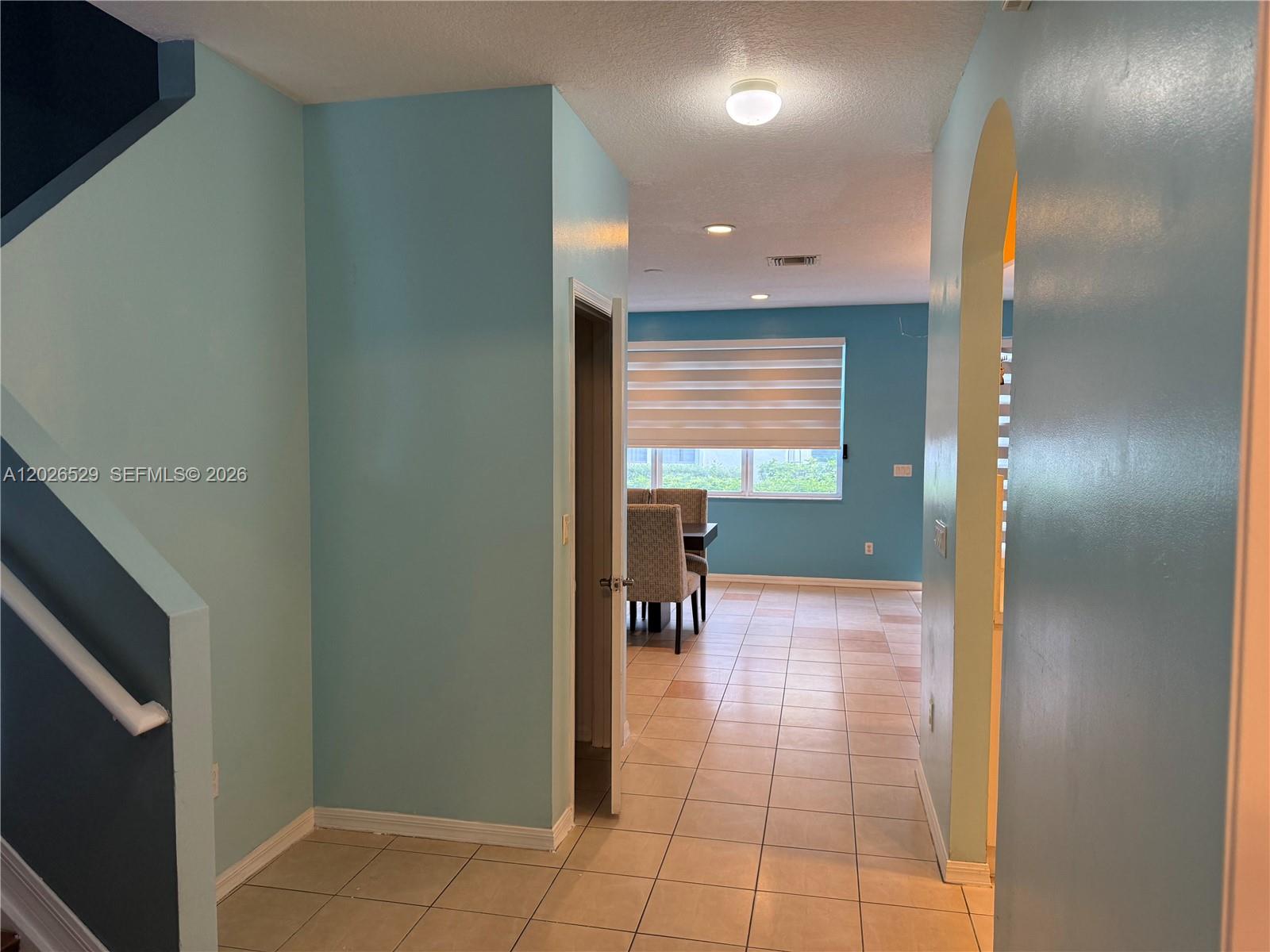 A tiled hallway leads to a dining area with light blue walls and a window — 4951 Mallory St # 4951, Lake Worth FL 33463, LAKE WORTH, FL