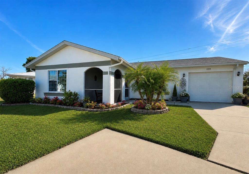A single-story house with a white exterior, a garage, and a landscaped front yard — 8181 MARLOW COURT, NORTH PORT, FL