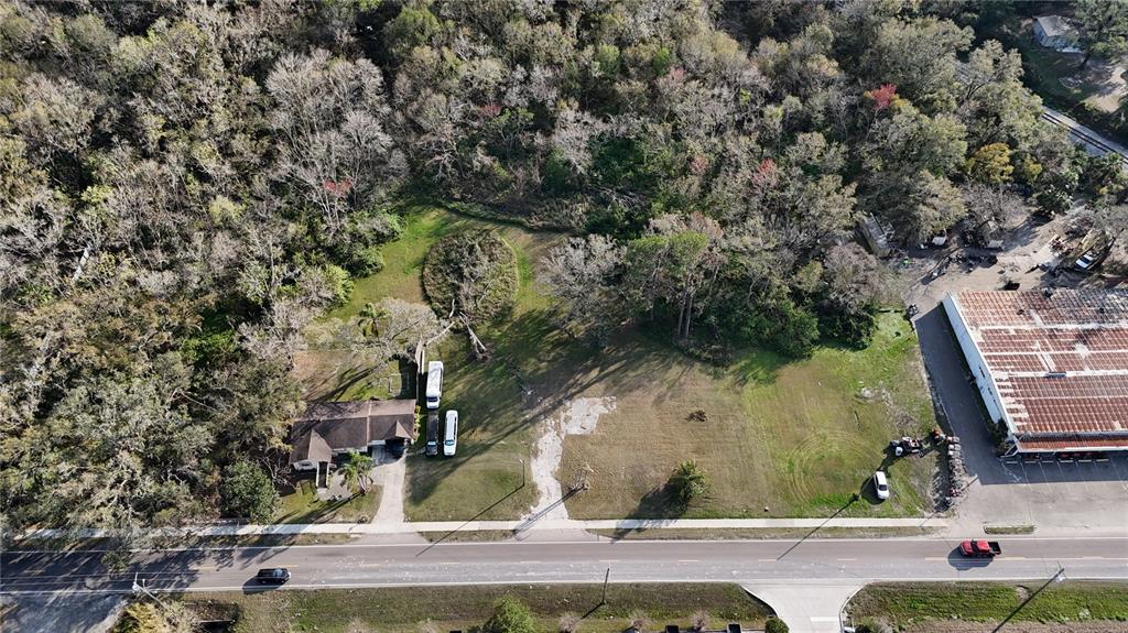 An aerial view shows a house, a large vacant lot, and a commercial building — 713 E ALSOBROOK STREET, PLANT CITY, FL