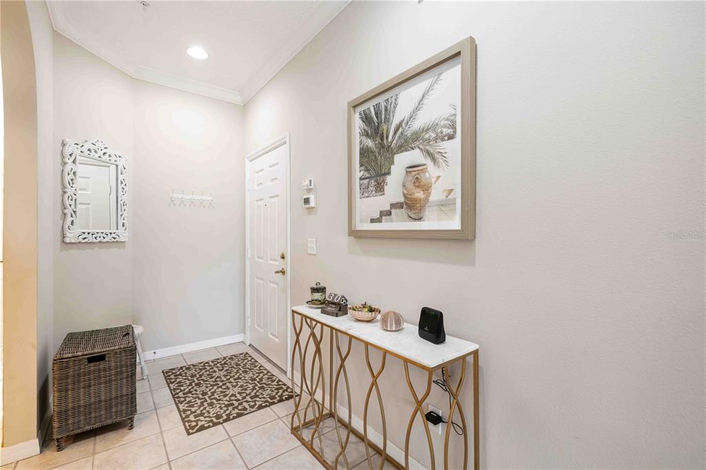 An entryway features a console table, a wall mirror, a patterned rug, and a door — 5064 MAHOGANY RUN AVENUE, SARASOTA, FL