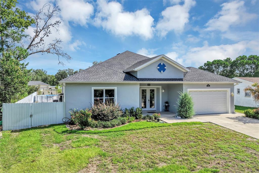 A single-story house with a gray exterior, a two-car garage, and a front lawn — 4501 SW 145TH PLACE ROAD, OCALA, FL