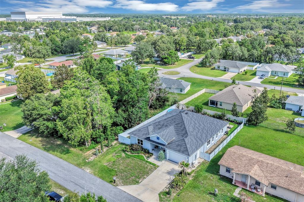 An aerial view shows a single-story house with a gray roof and a concrete driveway — 4501 SW 145TH PLACE ROAD, OCALA, FL