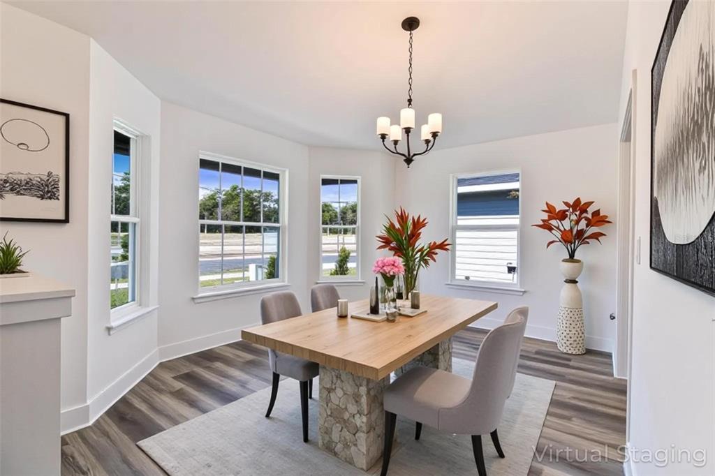 A dining room with a stone-based wooden table, grey chairs, and a chandelier — 16865 NW 176TH WAY, ALACHUA, FL