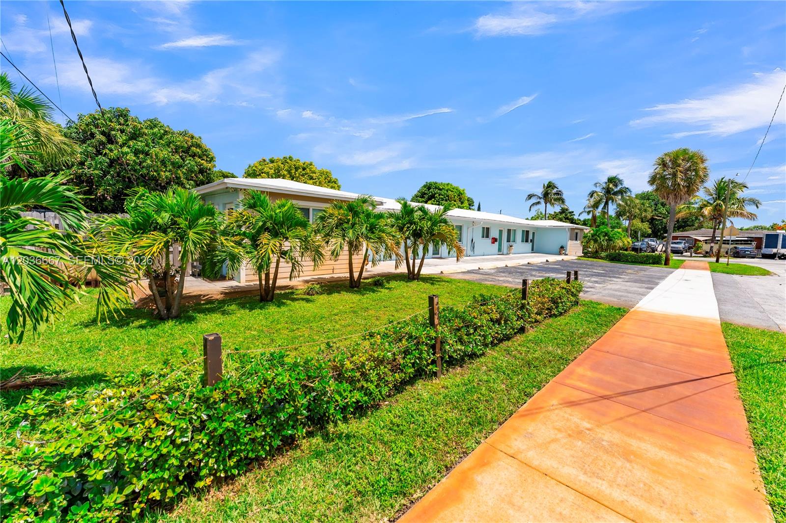A low-rise, light blue building with a palm-lined lawn and a sidewalk in the foreground — 4008 NW 5th Ave, Oakland Park FL 33309, OAKLAND PARK, FL