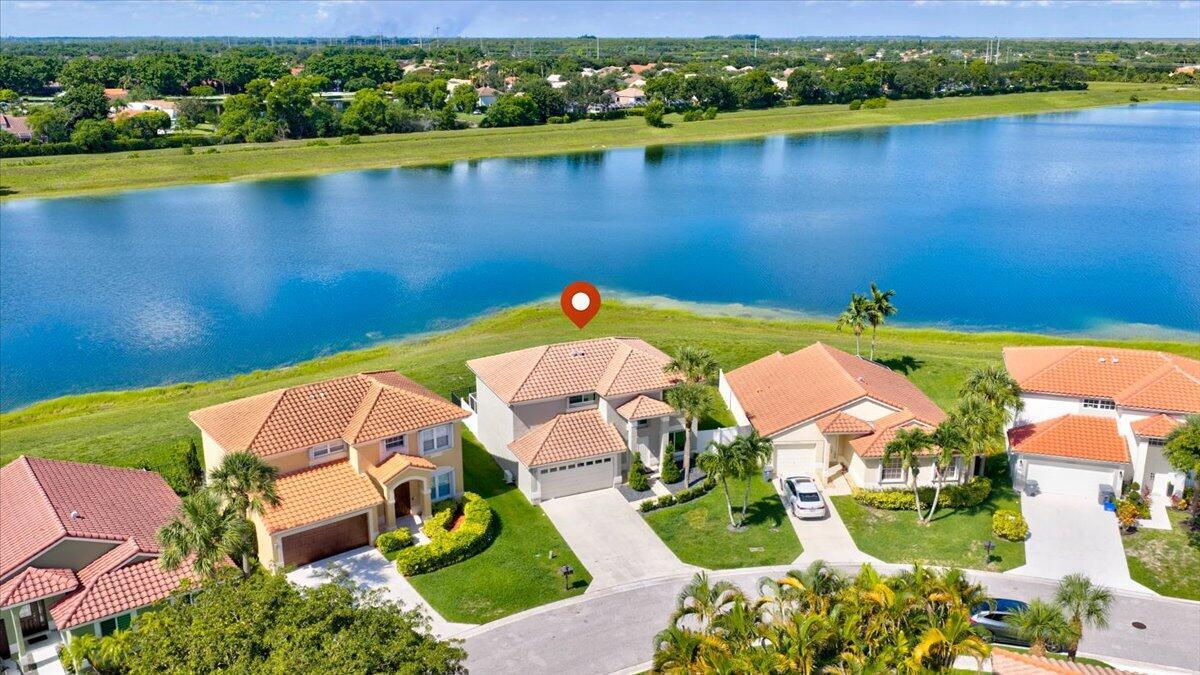 An aerial view shows a suburban house with a tile roof situated along a lake — 10712 Oak Lake Way, Boca Raton FL 33498, BOCA RATON, FL
