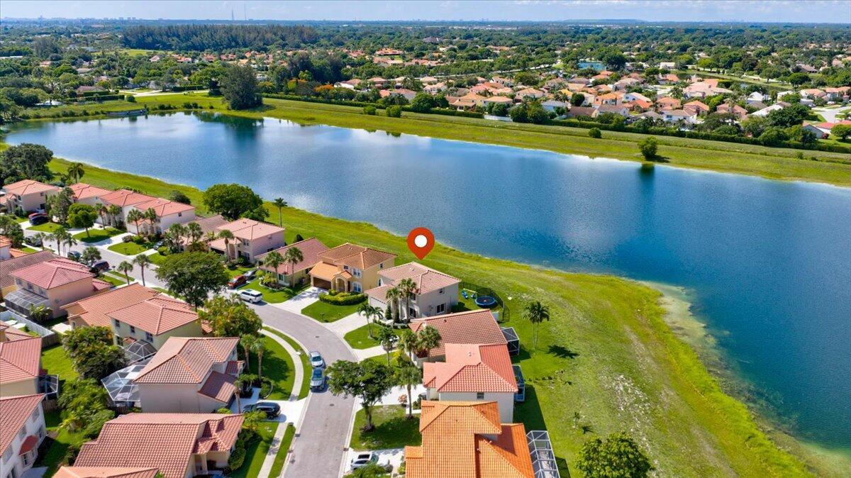 An aerial view of a suburban house with a tile roof situated beside a lake — 10712 Oak Lake Way, Boca Raton FL 33498, BOCA RATON, FL