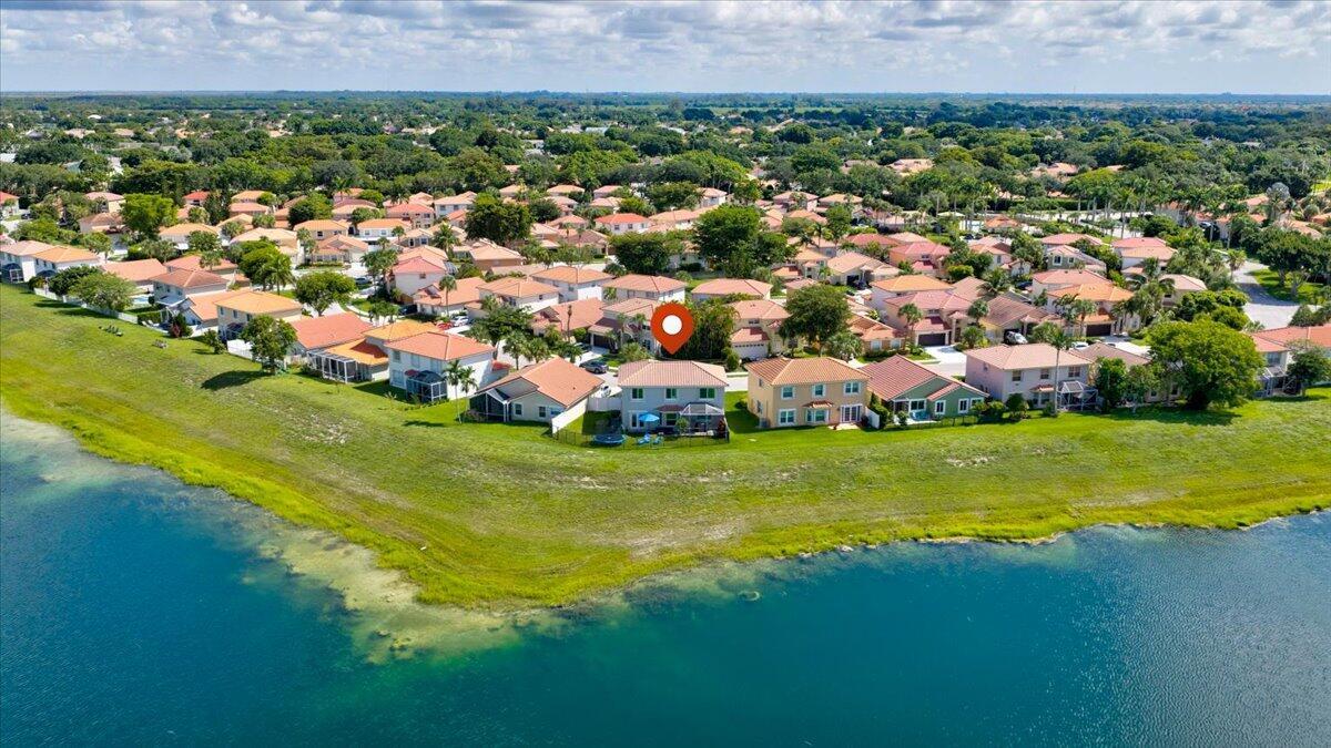 An aerial view of a suburban neighborhood featuring houses situated along a large lake — 10712 Oak Lake Way, Boca Raton FL 33498, BOCA RATON, FL