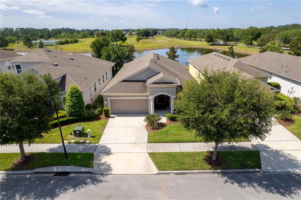 A single-story suburban house with a gray stucco exterior, a two-car garage, and arched entryway — 3304 SAGEBRUSH STREET, HARMONY, FL