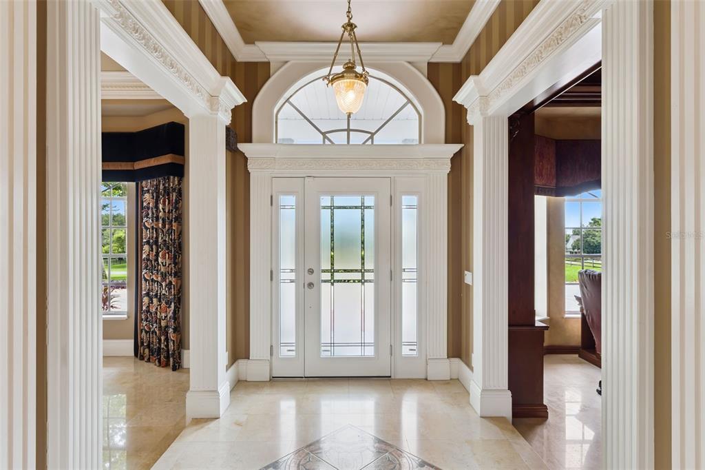 A white house with a red roof and a detached garage sits on a lawn — 15000 THOROUGHBRED LN, MONTVERDE, FL