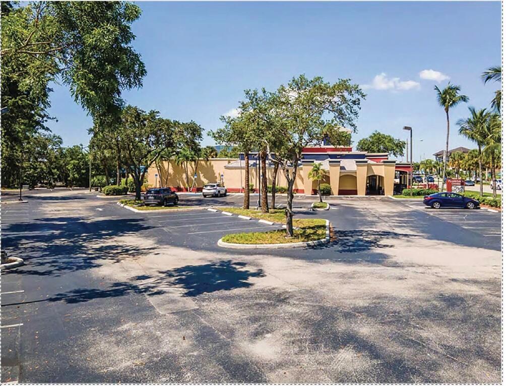 An exterior view of a commercial building with a large paved parking lot and trees — 1450 N Federal Highway, Boca Raton FL 33432, BOCA RATON, FL