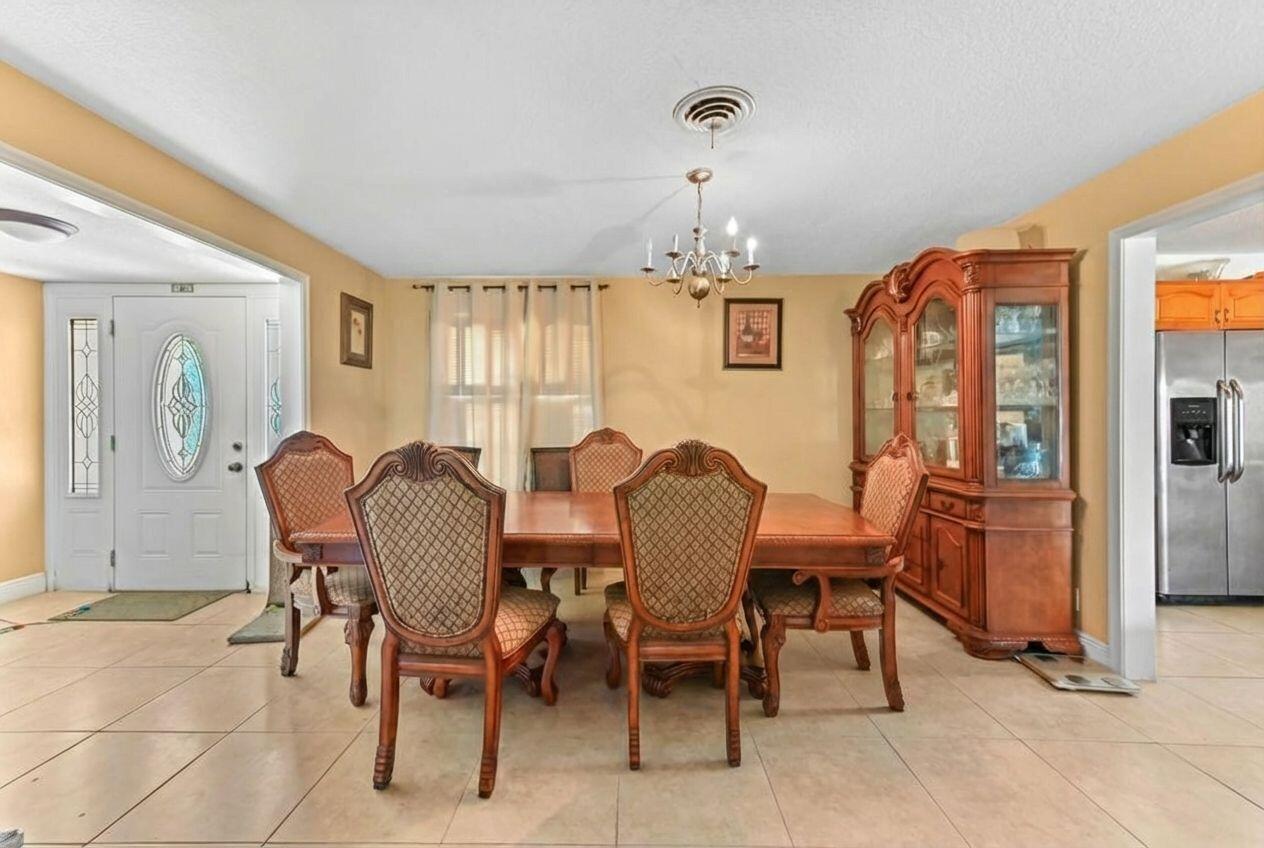 A dining room with a wooden table, six chairs, a china cabinet, and tile flooring — 315 SW 12th Avenue, Boynton Beach FL 33435, BOYNTON BEACH, FL