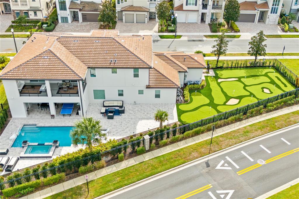 An aerial view shows a house with a swimming pool and a backyard putting green — 7933 JACKS CLUB DRIVE, REUNION, FL