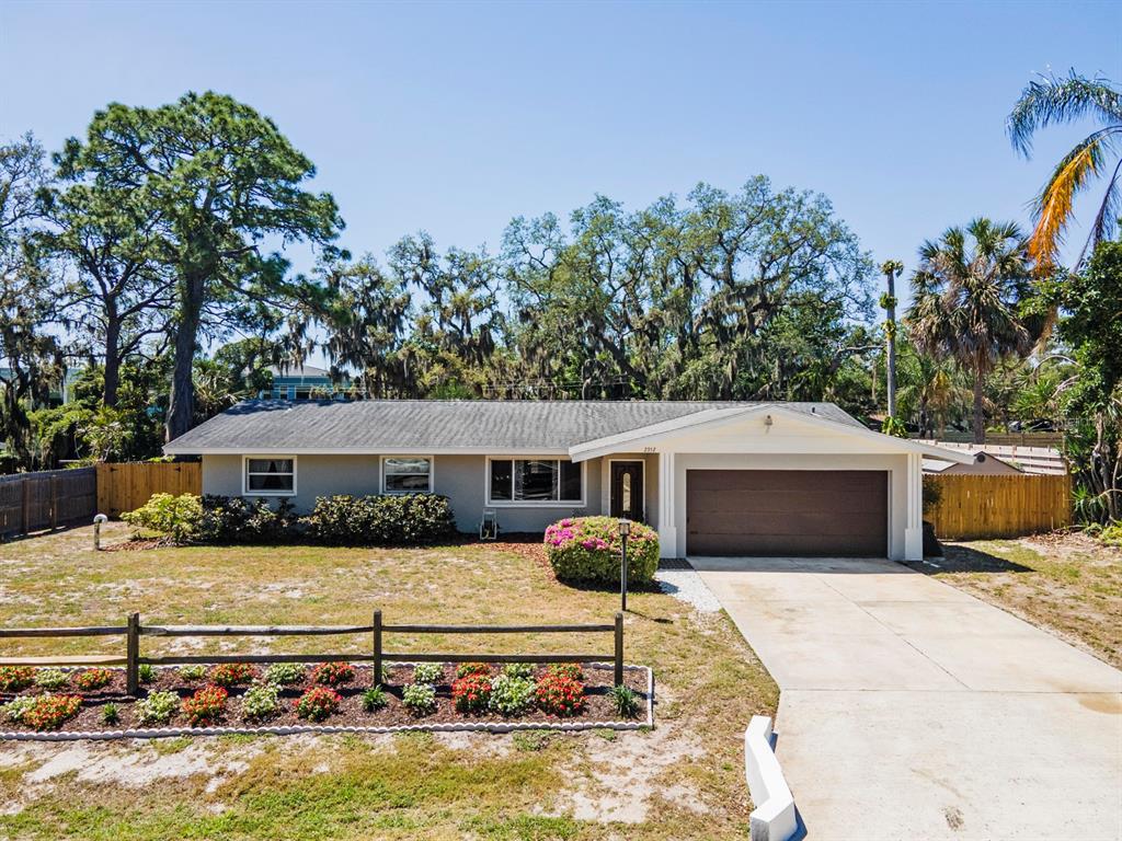 A single-story house with a gray exterior, a two-car garage, and a front flower bed — 2352 PALM TERRACE, SARASOTA, FL