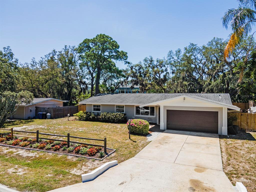 A single-story house with a two-car garage, a front lawn, and a wooden fence — 2352 PALM TERRACE, SARASOTA, FL