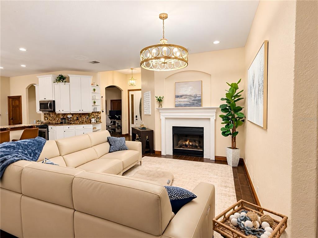 A covered patio with brick pavers overlooks a swimming pool and a lake — 17802 SAINT LUCIA ISLE DRIVE, TAMPA, FL