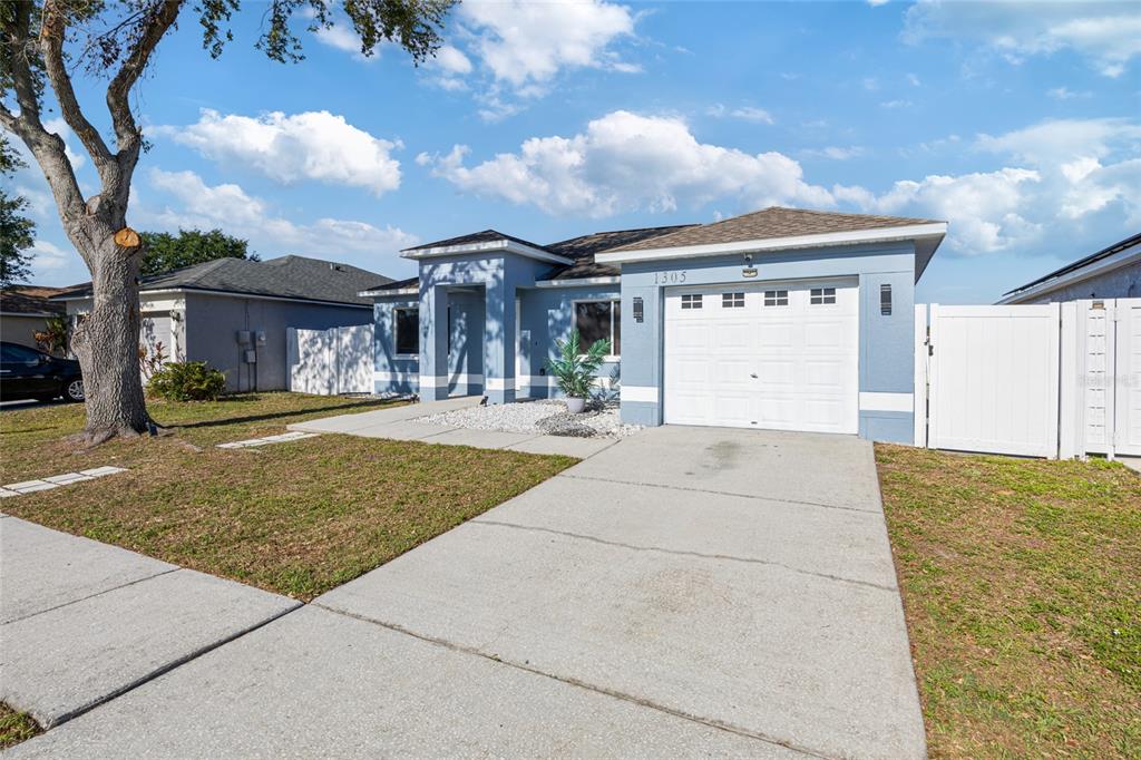 A blue single-story house with a white garage door and a concrete driveway — 1305 FLEXFORD STREET, BRANDON, FL