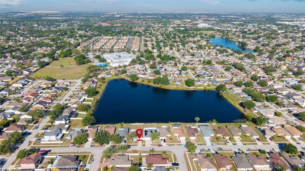 An aerial view shows a residential neighborhood with a large lake and a marked property — 1305 FLEXFORD STREET, BRANDON, FL