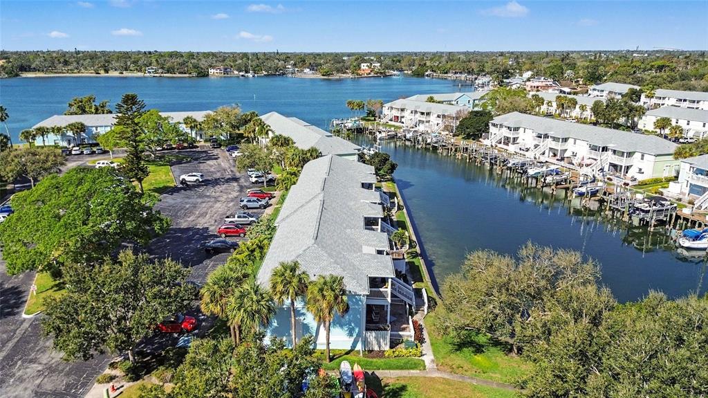 An aerial view shows waterfront residential buildings with boat slips and a parking lot — 5176 SALMON DRIVE SE UNIT D, ST PETERSBURG, FL