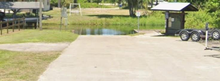 A concrete boat ramp leads into a small body of water near a covered kiosk — 455 NICHELE BOULEVARD, LAKE PLACID, FL